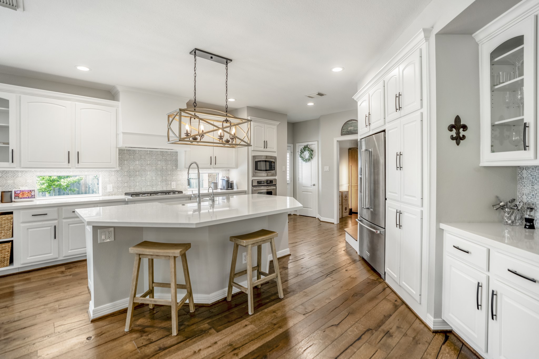 9707 Blue Cruls Way Spring, TX 77379 - Photo 25 of 50 a kitchen with kitchen island granite countertop a table chairs refrigerator and cabinets