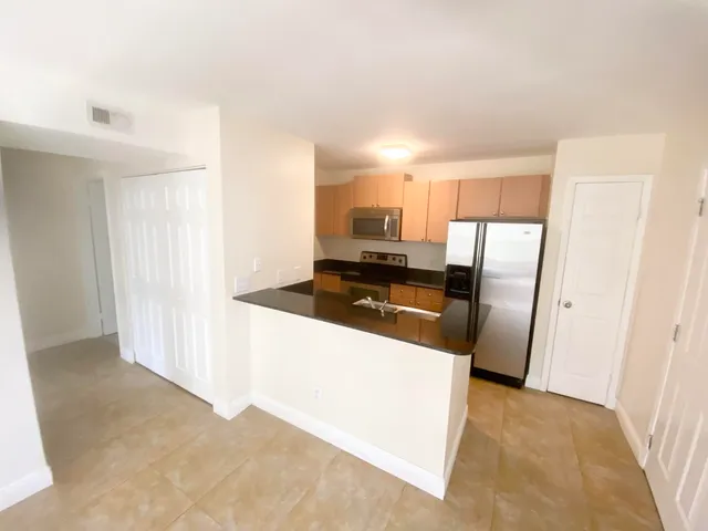 a kitchen with granite countertop a refrigerator and a sink