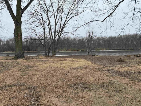 a view of yard with large tree and wooden fence