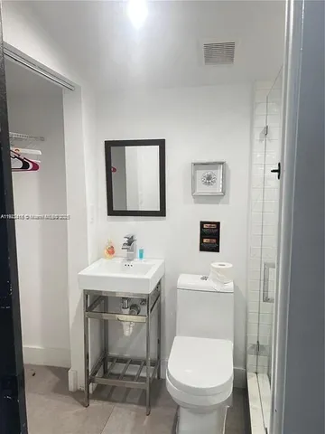 a bathroom with a toilet a sink and mirror