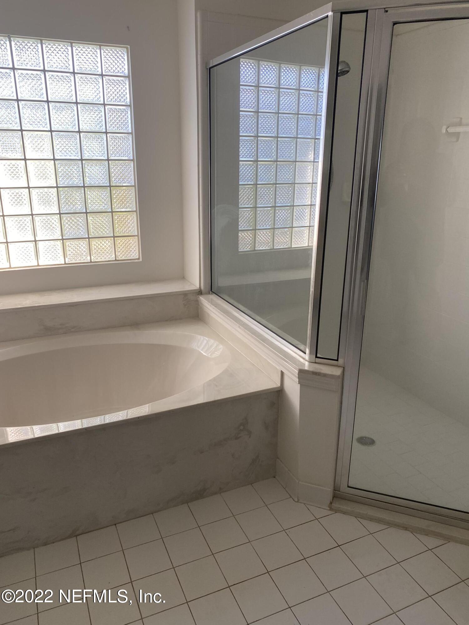 627 Cherry Street Neptune Beach, FL 32266 - Photo 13 of 17 a bathroom with a bathtub and next to a window