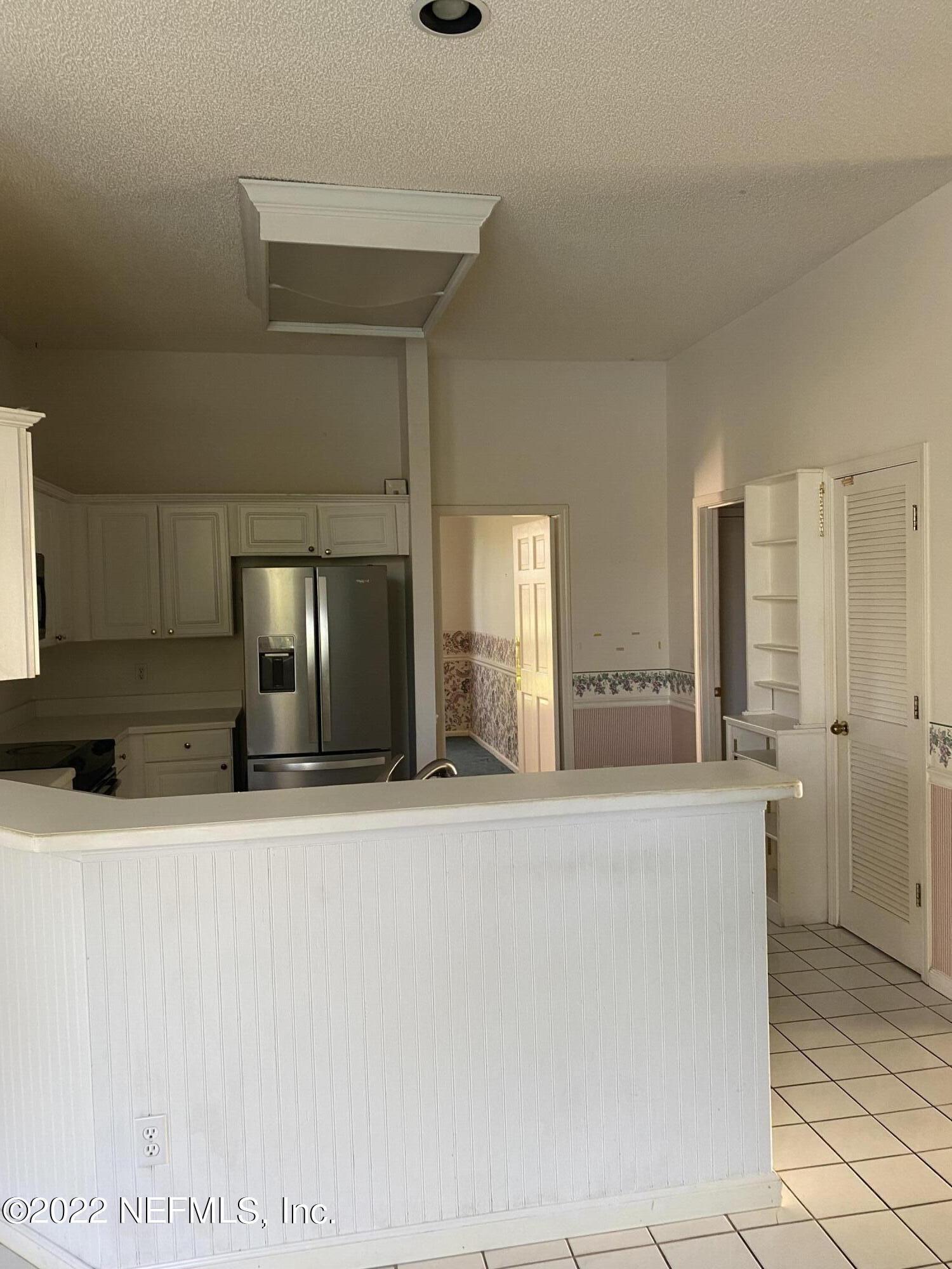 627 Cherry Street Neptune Beach, FL 32266 - Photo 6 of 17 a view of a kitchen with kitchen island a sink and refrigerator