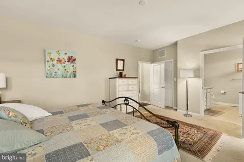 a bedroom with a bed and a large mirror on the dresser