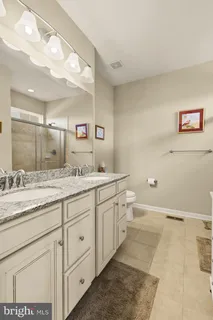 a spacious bathroom with a granite countertop sink mirror and toilet