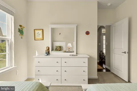a room with a bed and a mirror on the dresser