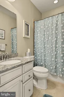 a bathroom with a granite countertop toilet sink and mirror