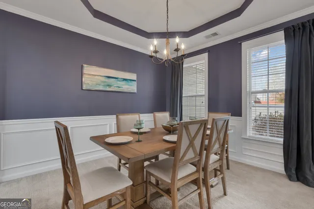a kitchen with a dining table chairs stainless steel appliances and cabinets