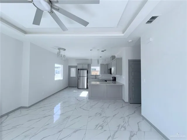 a view of a kitchen with a sink and dishwasher a refrigerator with wooden floor