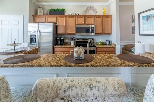 a kitchen with stainless steel appliances granite countertop a refrigerator a stove top oven and a sink