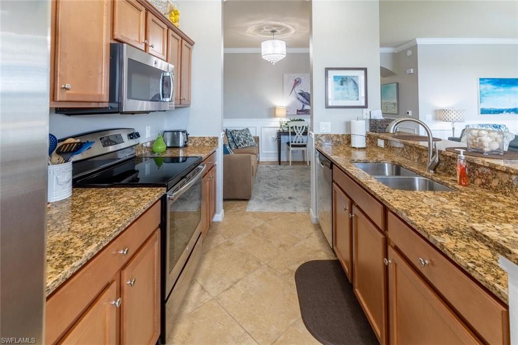 9731 Acqua Court, Unit 541 Naples, FL 34113 - Photo 12 of 48 a kitchen with kitchen island granite countertop a stove a sink and a granite counter tops