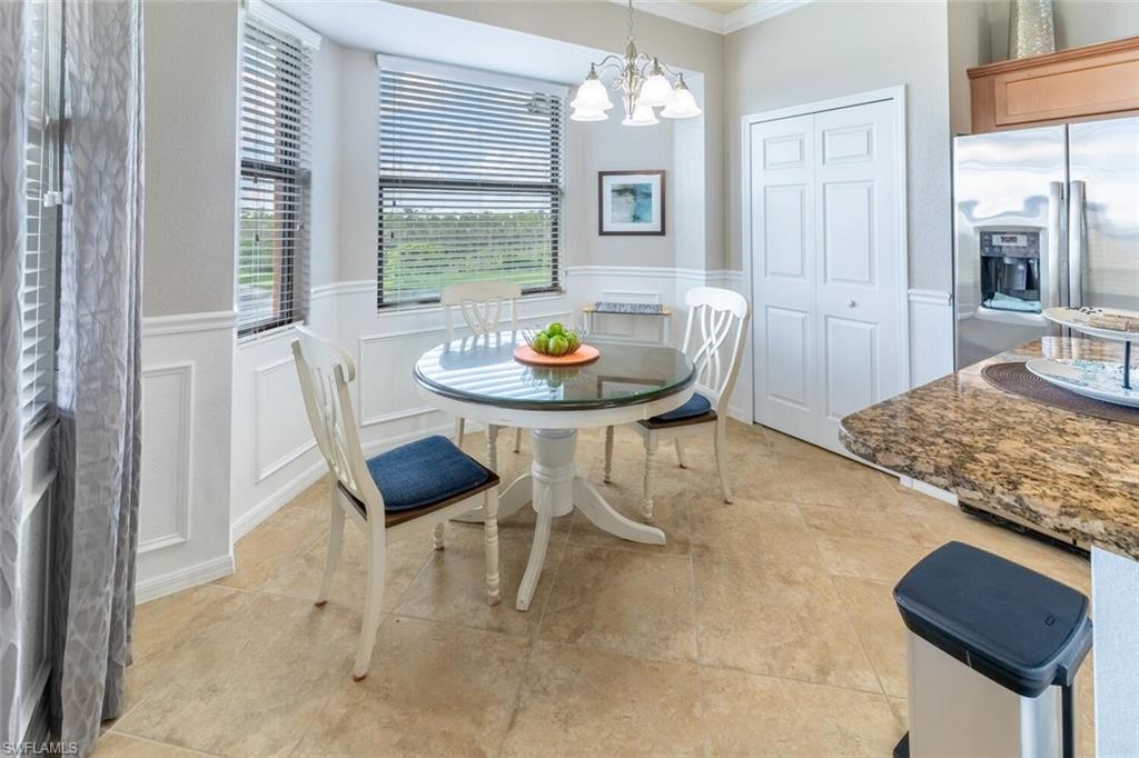 9731 Acqua Court, Unit 541 Naples, FL 34113 - Photo 13 of 48 a view of a dining room with furniture and a chandelier
