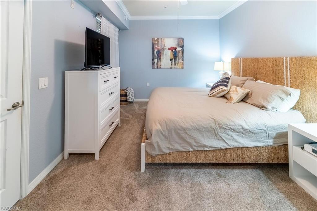 9731 Acqua Court, Unit 541 Naples, FL 34113 - Photo 16 of 48 a bedroom with a bed and a flat screen tv