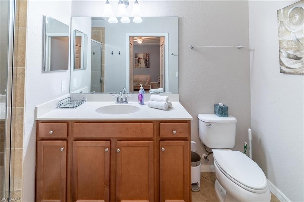 9731 Acqua Court, Unit 541 Naples, FL 34113 - Photo 17 of 48 a bathroom with a toilet a sink and mirror