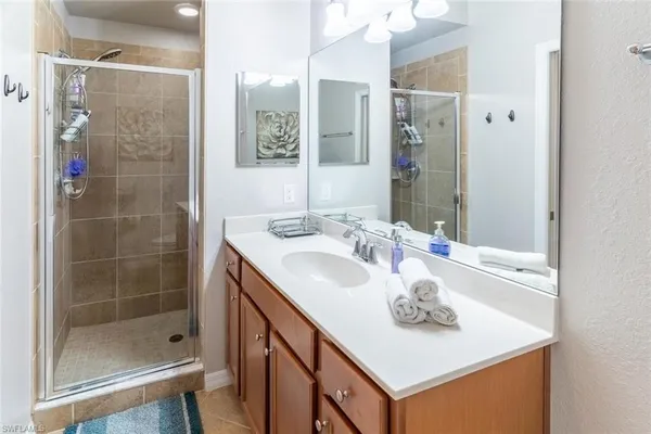 a bathroom with a sink a shower and a mirror
