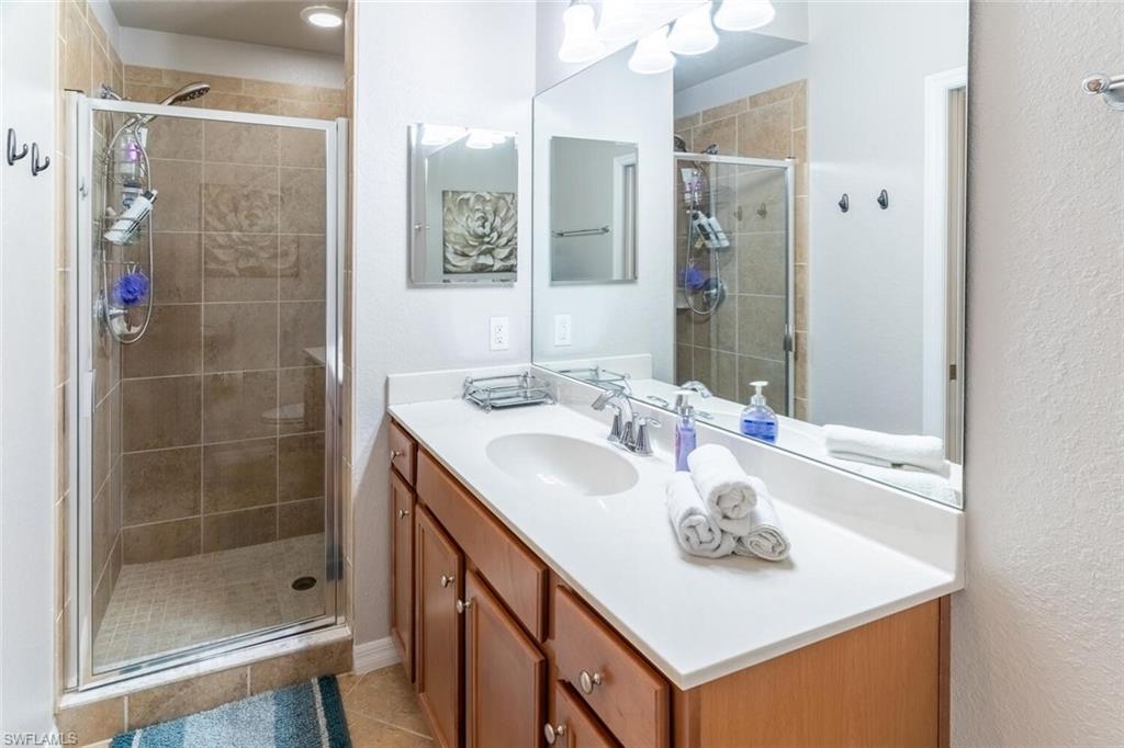 9731 Acqua Court, Unit 541 Naples, FL 34113 - Photo 18 of 48 a bathroom with a sink a shower and a mirror