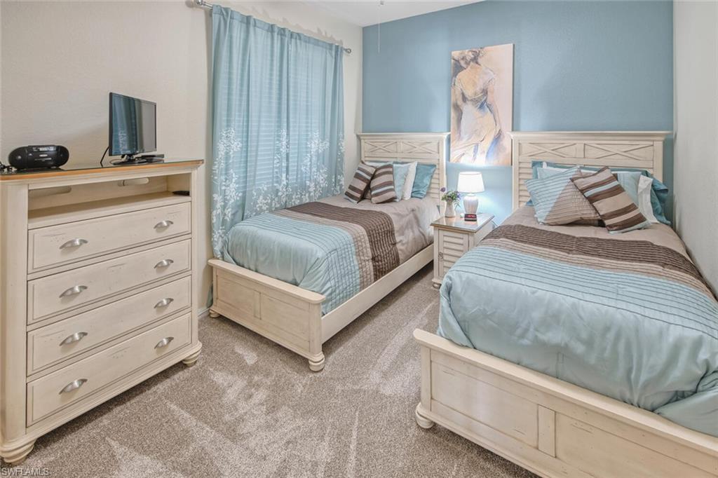 9731 Acqua Court, Unit 541 Naples, FL 34113 - Photo 20 of 48 a bedroom with a bed and a flat screen tv