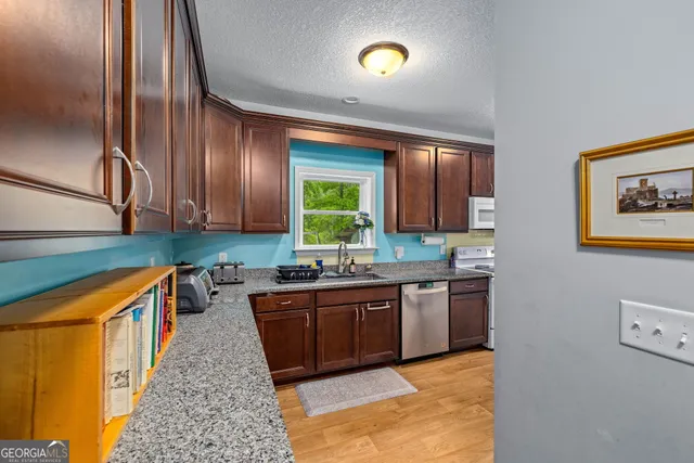 a kitchen with stainless steel appliances granite countertop a sink a stove and a refrigerator