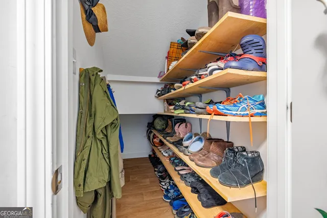 a view of walk in closet with clothes and shoes