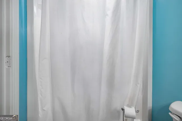 a bathroom with a shower curtain and a curtain
