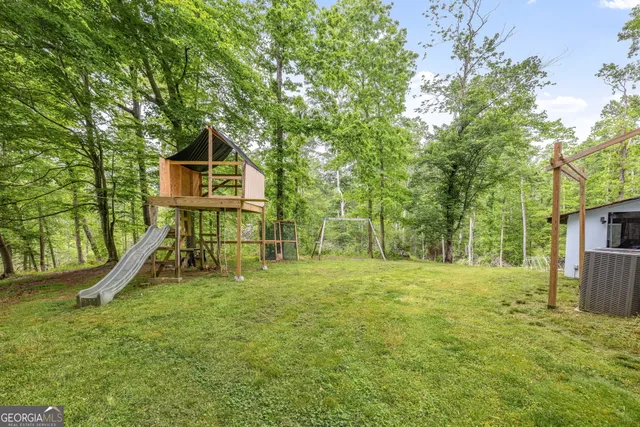 a view of a house with backyard and trees