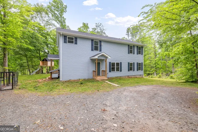 a view of a house with backyard and sitting area
