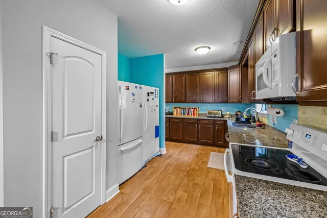 a kitchen with stainless steel appliances granite countertop a refrigerator and a stove