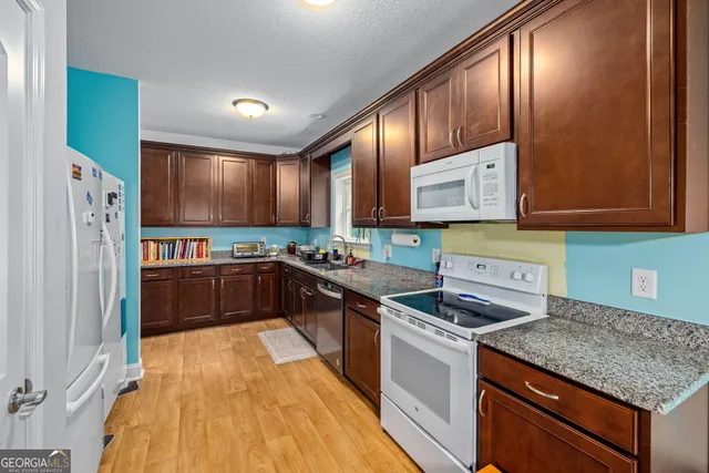 a kitchen with stainless steel appliances granite countertop a stove a sink and a microwave
