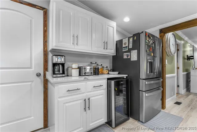 a kitchen with stainless steel appliances white cabinets and a refrigerator