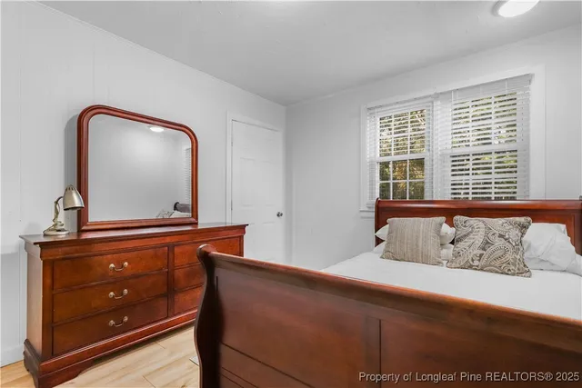 a bedroom with a bed and a mirror on dresser