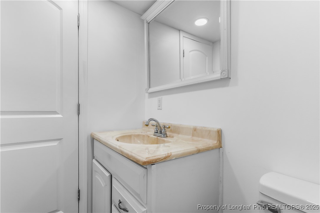 1855 Beaman Woods Road Clinton, NC 28328 - Photo 28 of 50 a bathroom with a sink a toilet and a mirror