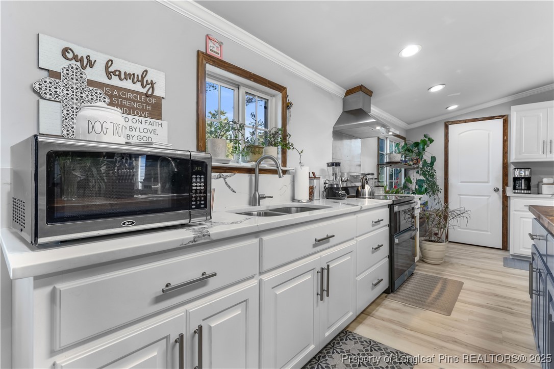 1855 Beaman Woods Road Clinton, NC 28328 - Photo 7 of 50 a kitchen with stainless steel appliances kitchen island granite countertop a sink and cabinets
