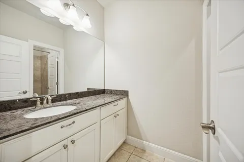 a bathroom with a granite countertop sink and a mirror