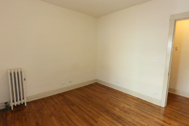 4716 North Racine Avenue, Unit 2E Chicago, IL 60640 - Photo 10 of 19 an empty room with wooden floor and a window