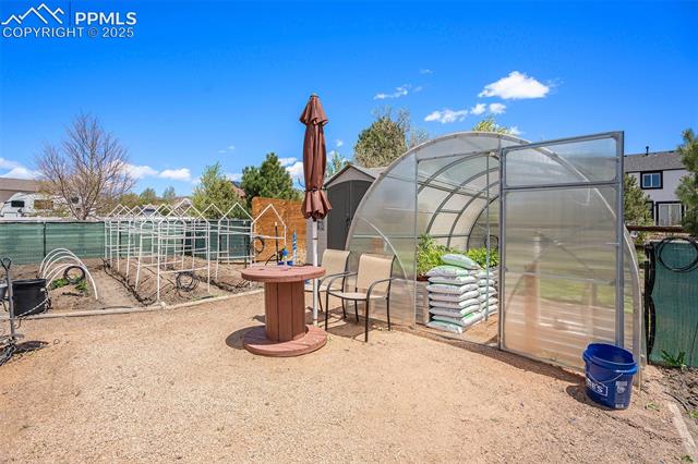 9709 Rockingham Drive Peyton, CO 80831 - Photo 44 of 50 Backyard greenhouse and garden fully equipped with drip line and shed.