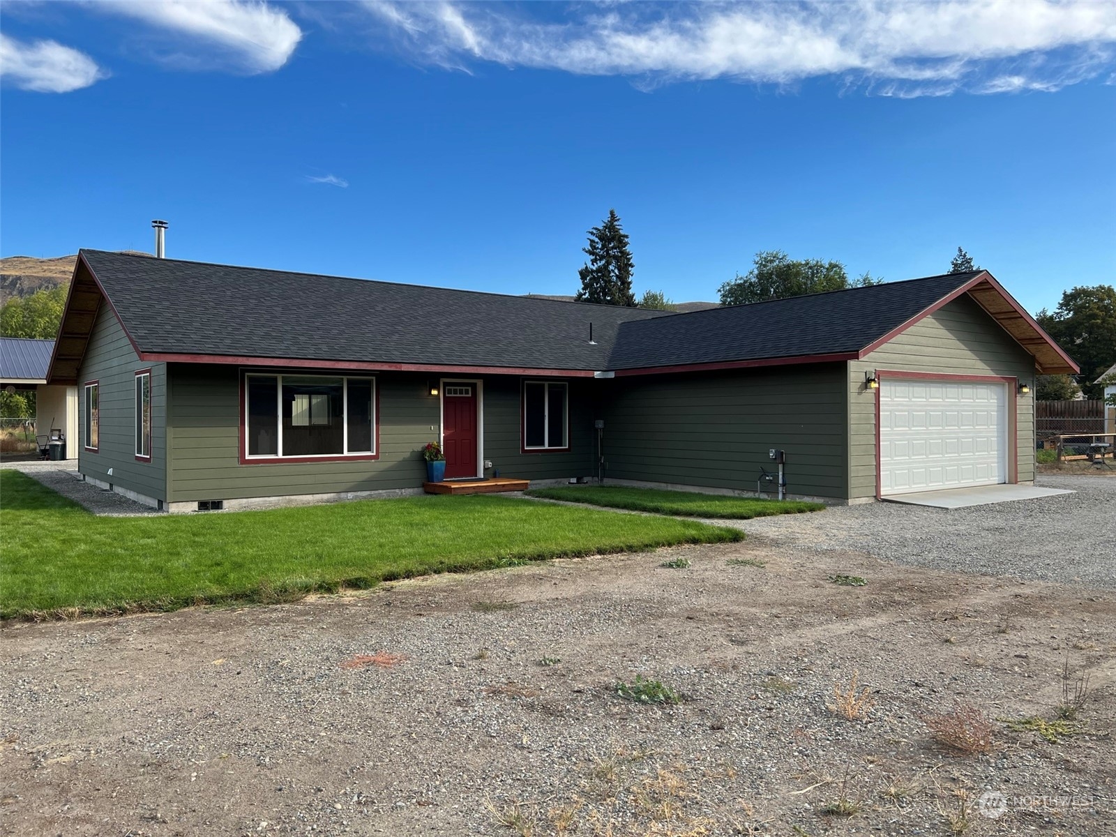 1004 Riverside Avenue Twisp, WA 98856 - Photo 18 of 40 a front view of a house with a yard and garage
