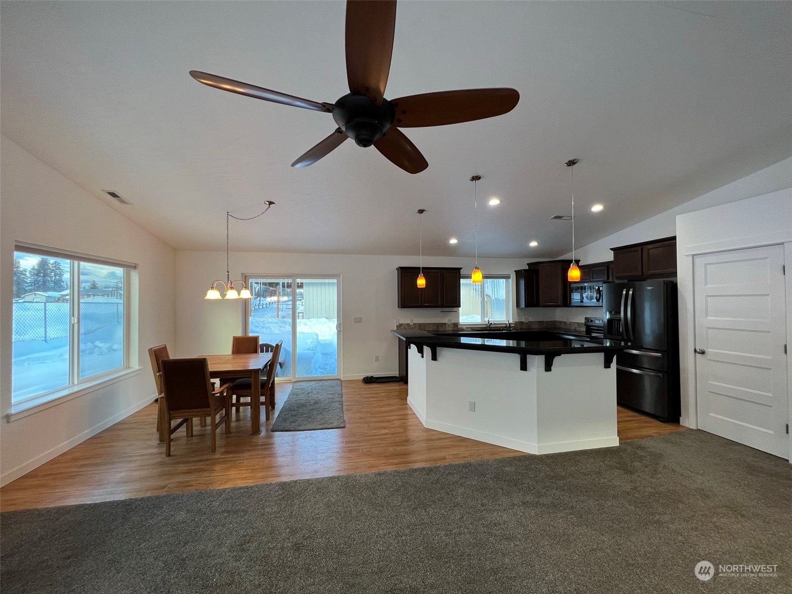 1004 Riverside Avenue Twisp, WA 98856 - Photo 7 of 40 a kitchen with stainless steel appliances kitchen island granite countertop a table chairs and a refrigerator