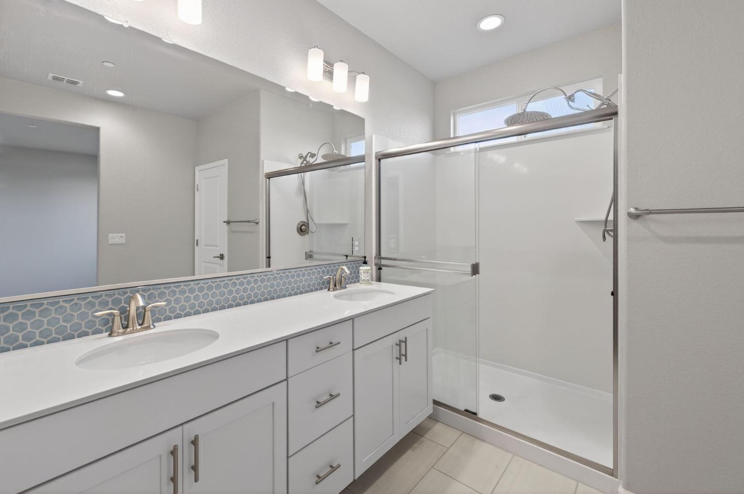 2431 Creekview Drive Merced, CA 95340 - Photo 36 of 38 a bathroom with a double vanity sink mirror and shower