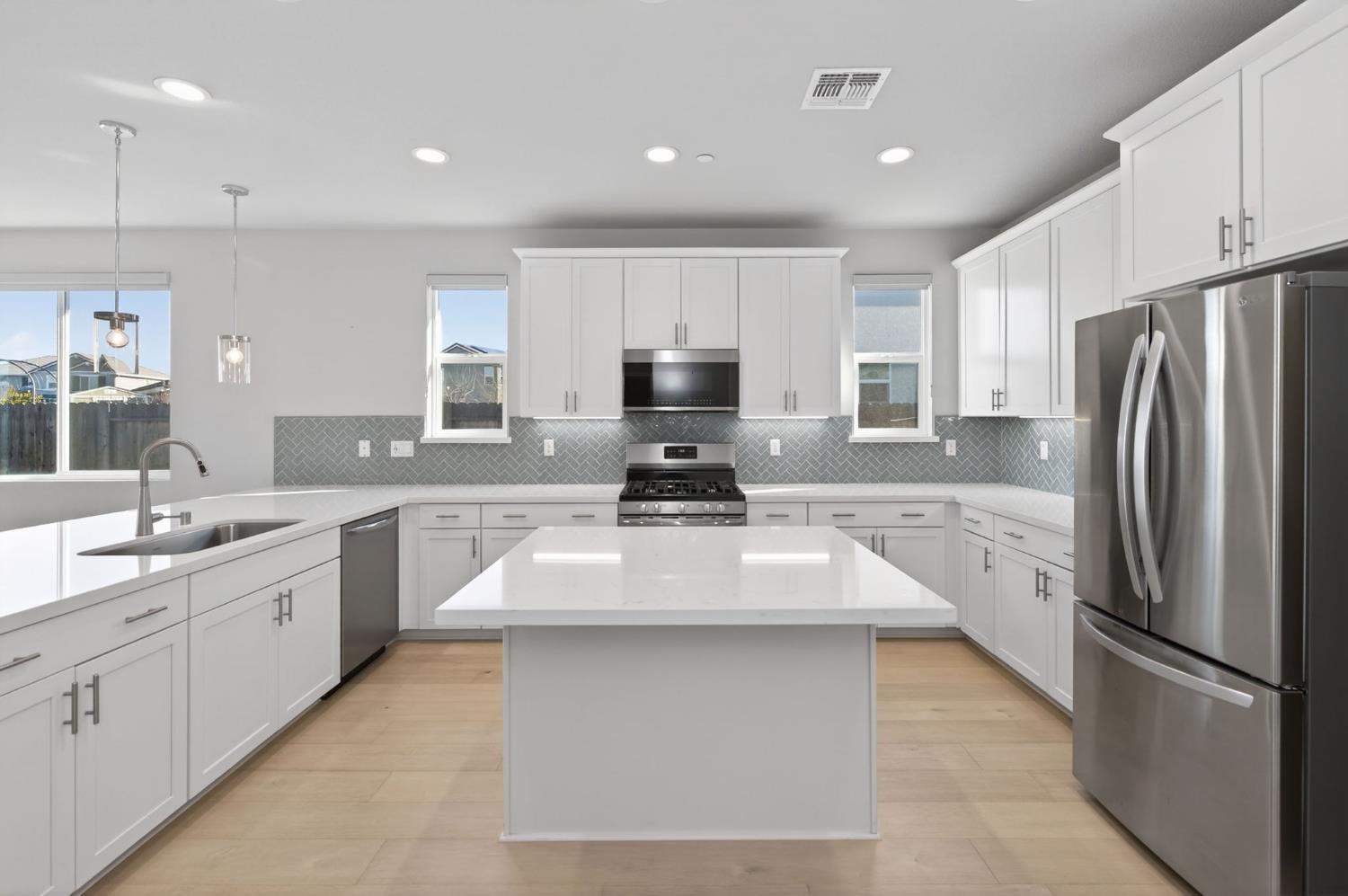2431 Creekview Drive Merced, CA 95340 - Photo 5 of 38 a kitchen with granite countertop a refrigerator sink and microwave