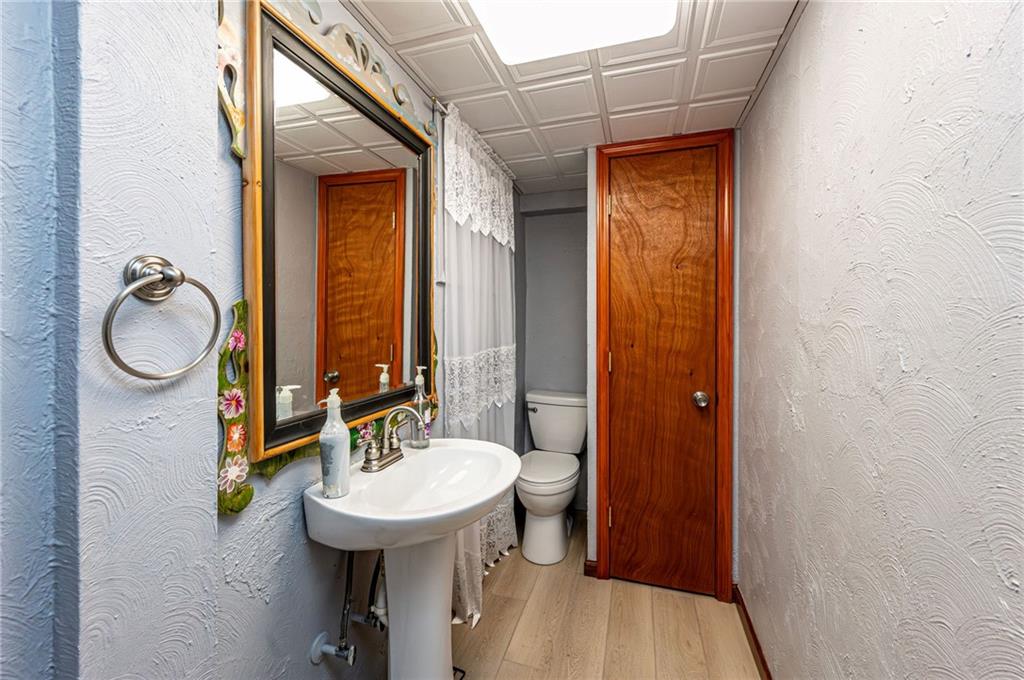 621 Sandy Hill Road Irwin, PA 15642 - Photo 34 of 50 a bathroom with a sink a mirror a toilet and a window