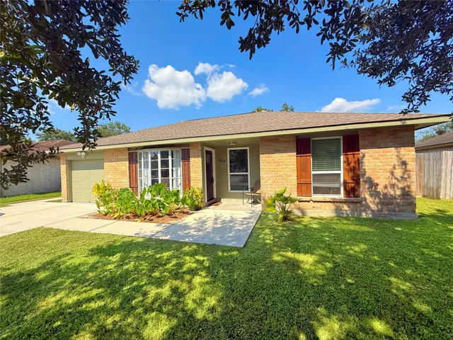 a view of a house with backyard and a tree