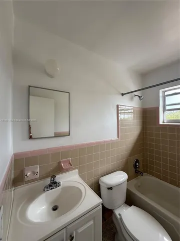 a bathroom with a sink mirror bathtub and toilet