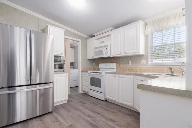 a kitchen with granite countertop white cabinets and stainless steel appliances