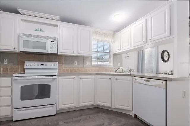 a kitchen with cabinets appliances a sink and a window
