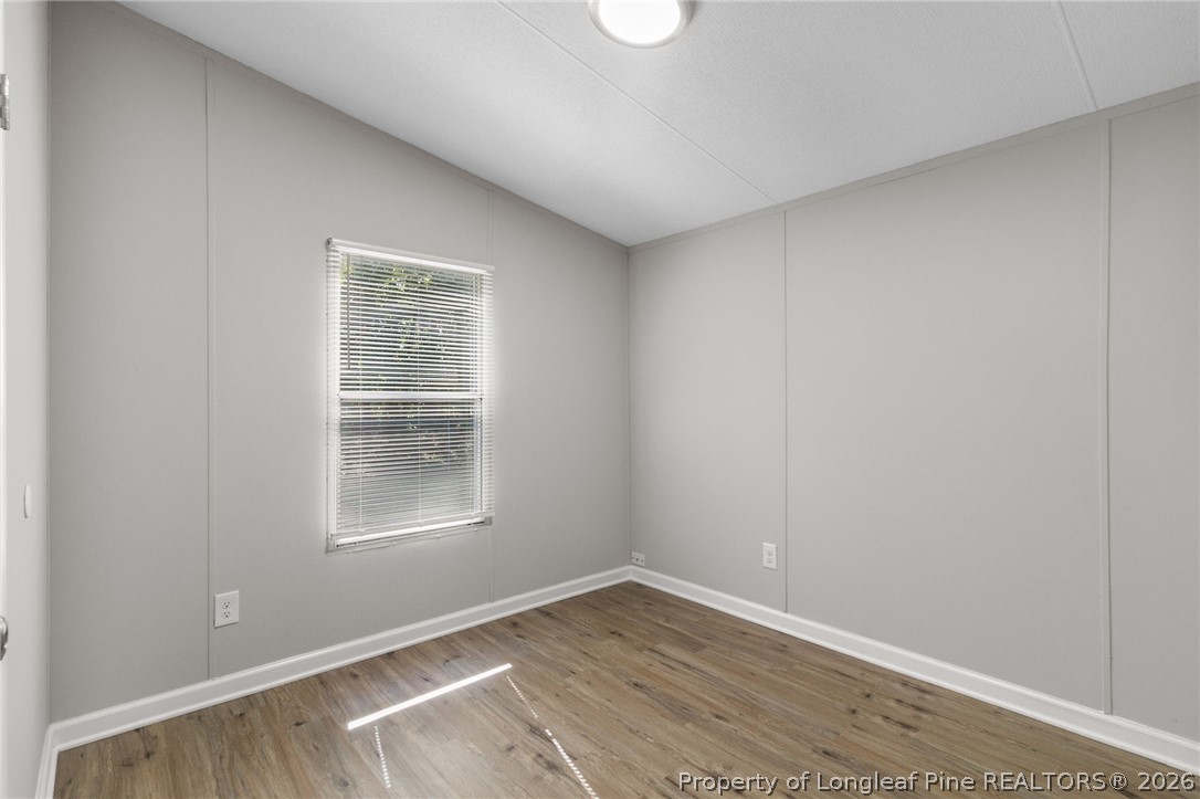 6568 Sandy Creek Road Stedman, NC 28391 - Photo 18 of 34 an empty room with wooden floor and windows