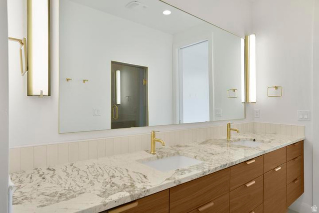 990 Manen Street Washington, UT 84780 - Photo 20 of 43 Dual vanity with gold-finish fixtures, a large continuous mirror, and under-mount sinks