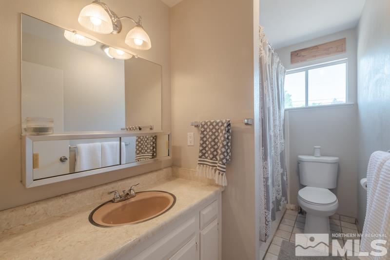 175 Greenstone Drive Reno, NV 89512 - Photo 17 of 33 a bathroom with a granite countertop sink a toilet and a mirror