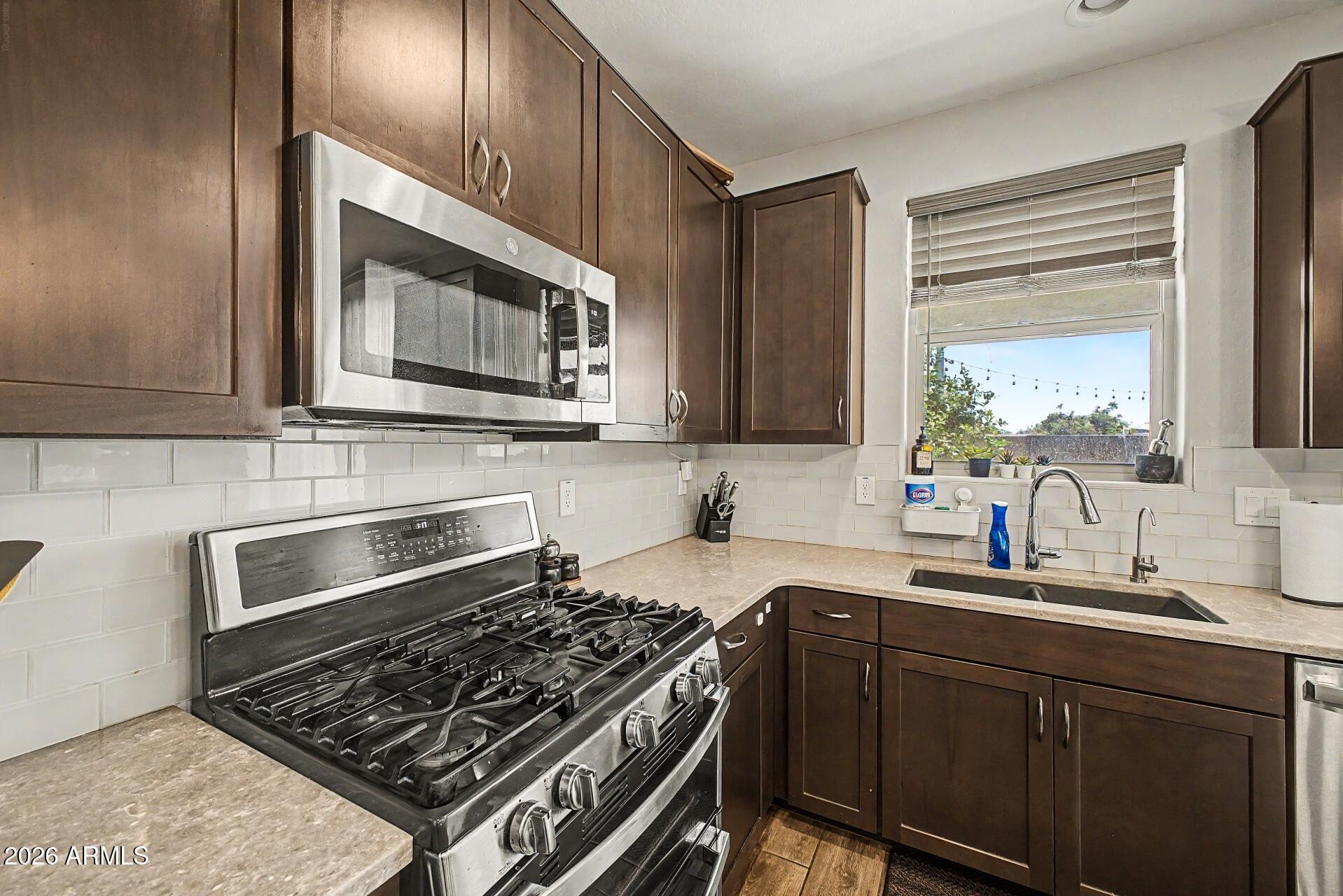 701 East Liberty Lane Gilbert, AZ 85296 - Photo 11 of 46 a kitchen with stainless steel appliances a stove sink and cabinets