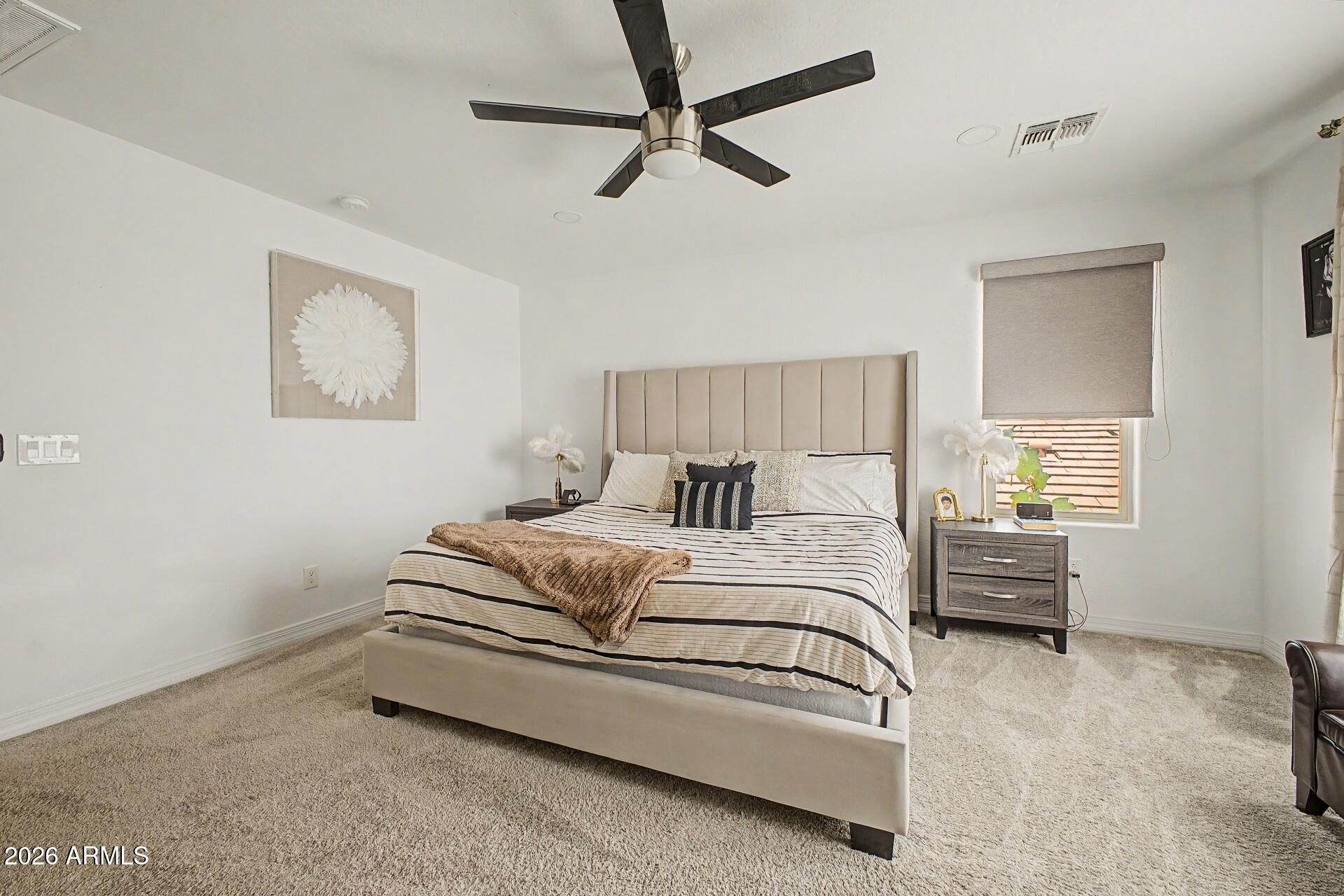 701 East Liberty Lane Gilbert, AZ 85296 - Photo 19 of 46 a spacious bedroom with a bed and a ceiling fan