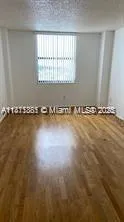 an empty room with wooden floor and a window