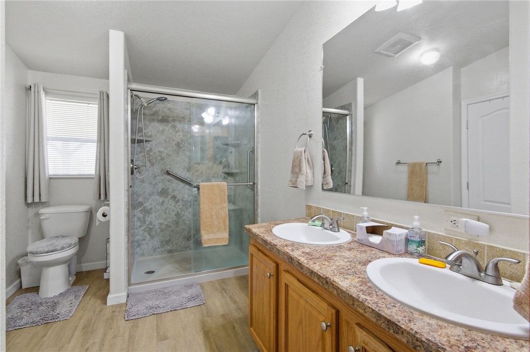 4342 Cordes Road Golden Valley, AZ 86413 - Photo 34 of 39 a bathroom with a granite countertop sink a toilet a mirror and shower